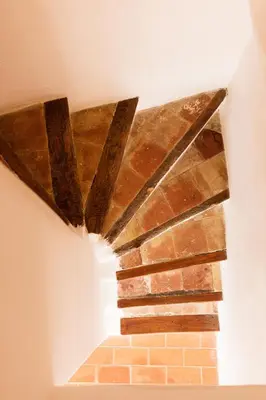 a brick wall with a ceiling with beams at Gîte La Maison des Vendangeurs in Villesèque-des-Corbières