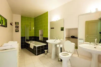 a bathroom with two sinks and a toilet and a tub at Gîte La Maison des Vendangeurs in Villesèque-des-Corbières