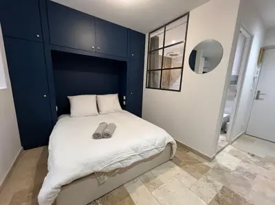 a bedroom with a bed with a pair of slippers on it at Le Merveilleux Voyage, Clim in Carcassonne