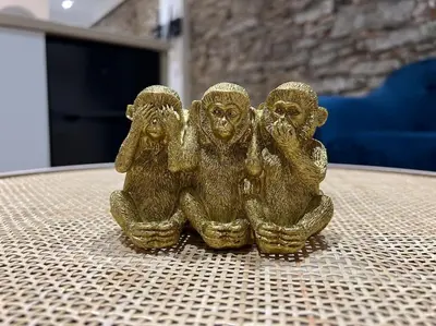 a gold figurine of three monkeys sitting on a table at Le Merveilleux Voyage, Clim in Carcassonne