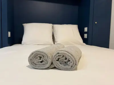 a bed with two towels on top of it at Le Merveilleux Voyage, Clim in Carcassonne