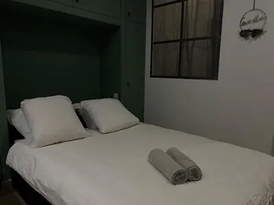 a bed with two pillows and two towels on it at Le Gîte Médiéval - Clim - Lave Linge - Cité in Carcassonne