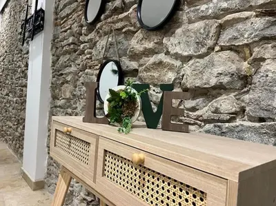 a wooden table in front of a stone wall at Le Gîte Médiéval - Clim - Lave Linge - Cité in Carcassonne