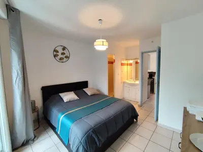 a bedroom with a bed and a bathroom at Appartement climatisé avec vue sur la cité in Carcassonne
