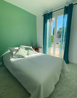 a bedroom with a large white bed and a window at Maison avec piscine et jardin in Salses-le-Chateau