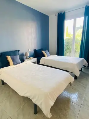 two beds in a room with blue walls at Maison avec piscine et jardin in Salses-le-Chateau