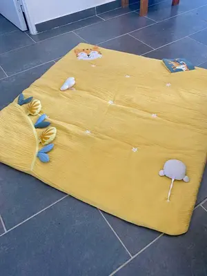 a yellow bed with toys on it on the floor at Maison avec piscine et jardin in Salses-le-Chateau