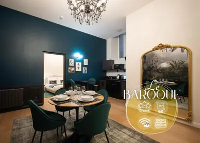 a dining room with a table and chairs and a mirror at Le Baroque - Grand T2 Confort, Lit Queen Size in Castres