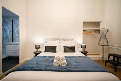 a bedroom with a large bed with shoes on it at Le Baroque - Grand T2 Confort, Lit Queen Size in Castres