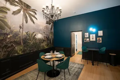 a dining room with a table and green chairs at Le Baroque - Grand T2 Confort, Lit Queen Size in Castres