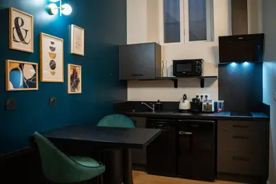 a kitchen with a table and chairs and a sink at Le Baroque - Grand T2 Confort, Lit Queen Size in Castres
