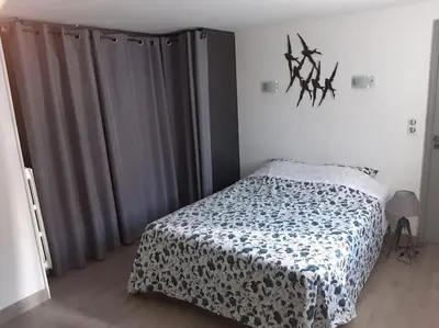 a bedroom with a bed with a blue and white blanket at Gite Beau Soleil in Roquecourbe