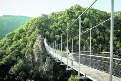 a woman standing on a suspension bridge over a mountain at Gite Beau Soleil in Roquecourbe