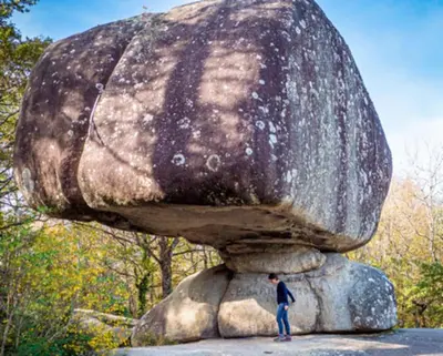 a man standing in front of a large rock statue at Gite Beau Soleil in Roquecourbe