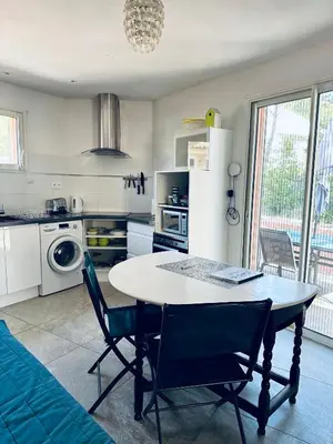 a kitchen with a table and chairs in a room at Moderne Mini Maison - Quartier Résidentiel Calme in Lézignan-Corbières