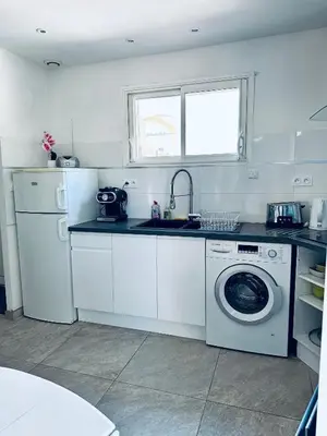 a kitchen with a washing machine and a sink at Moderne Mini Maison - Quartier Résidentiel Calme in Lézignan-Corbières