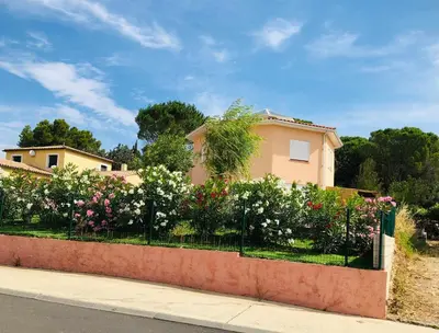 a fence with flowers in front of a house at Moderne Mini Maison - Quartier Résidentiel Calme in Lézignan-Corbières
