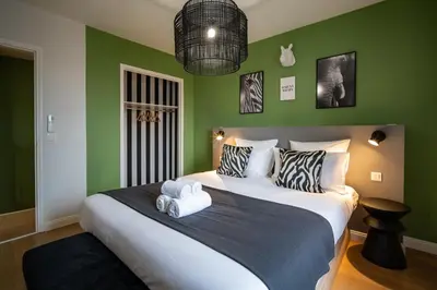 a bedroom with a large bed with green walls at Le Savane - Grand Triplex Confort & Chaleureux, 2 Salons in Castres