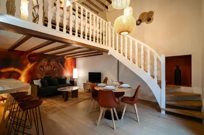 a living room with a staircase and a living room with a table at Le Savane - Grand Triplex Confort & Chaleureux, 2 Salons in Castres