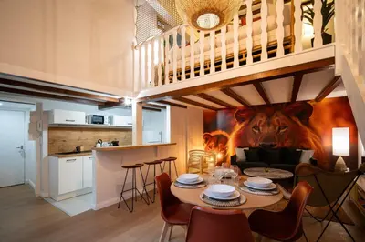 a dining room with a table and a lion mural at Le Savane - Grand Triplex Confort & Chaleureux, 2 Salons in Castres