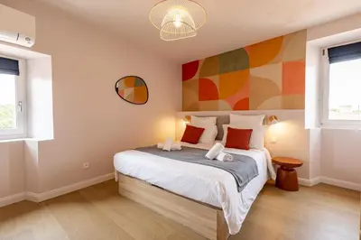 a bedroom with a bed with a colorful wall at Le Terracotta - Grand Triplex Confort & Chaleureux in Castres