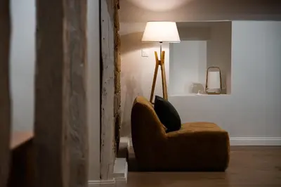 a living room with a chair and a lamp at Le Terracotta - Grand Triplex Confort & Chaleureux in Castres