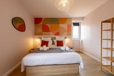 a bedroom with a bed with a painting on the wall at Le Terracotta - Grand Triplex Confort & Chaleureux in Castres