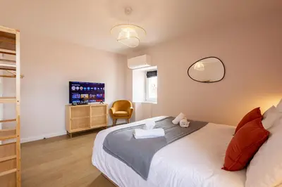 a bedroom with a bed with a mirror and a television at Le Terracotta - Grand Triplex Confort & Chaleureux in Castres