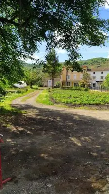 a dirt road with a building in the background at Agréable maison au bord de la rivière in Campagne-sur-Aude