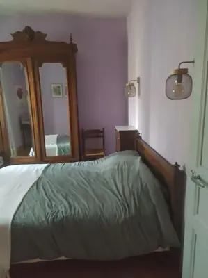 a bedroom with a bed and a large mirror at Agréable maison au bord de la rivière in Campagne-sur-Aude