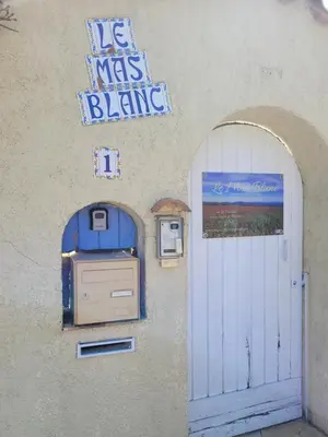 a building with a blue gas meter and a sign at LeMasBlanc, Chambre d'hôtes & jacuzzi privé, au calme, 15min de Carcassonne in Malves-en-Minervois