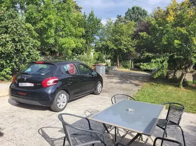 a small black car parked next to a table at Maisonnette indépendante 48m2 , parking privé, calme & confort in Lagarrigue