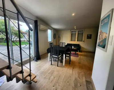 a living room with a table and a dining room at Maisonnette indépendante 48m2 , parking privé, calme & confort in Lagarrigue