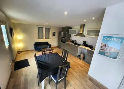 a living room with a dining table and a kitchen at Maisonnette indépendante 48m2 , parking privé, calme & confort in Lagarrigue