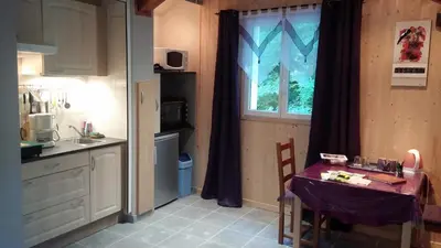 a small kitchen with a table and a window at Moulin de Record in Ferrières