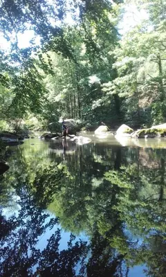 a person standing in the middle of a river at Moulin de Record in Ferrières