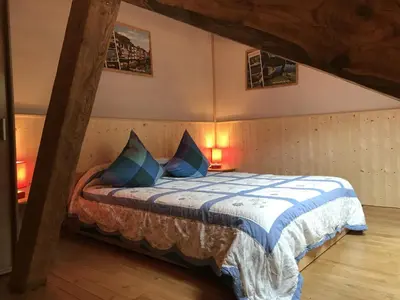 a bedroom with a bed with blue pillows on it at Moulin de Record in Ferrières
