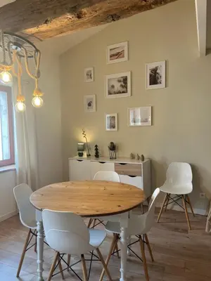 a dining room with a wooden table and white chairs at Charmant appartement centre ville de Castres in Castres