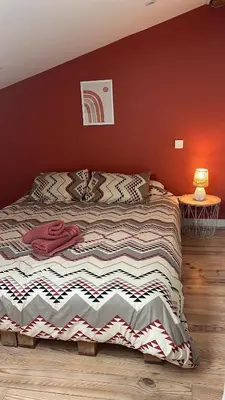 a bed in a bedroom with a red wall at Charmant appartement centre ville de Castres in Castres