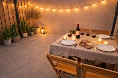 a table with glasses of wine and candles on it at Terrasse Privée - 4 Voyageurs - Proche Cité de Carcassonne in Carcassonne