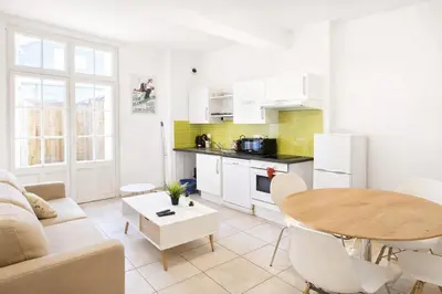 a living room with a table and a kitchen at Terrasse Privée - 4 Voyageurs - Proche Cité de Carcassonne in Carcassonne