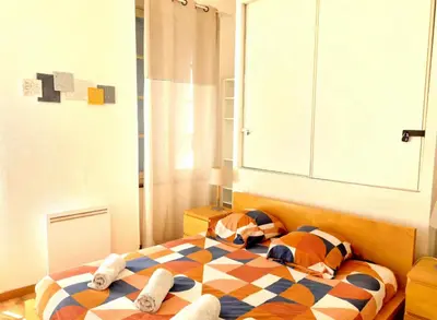a bedroom with a bed with a checkered blanket at Terrasse Privée - 4 Voyageurs - Proche Cité de Carcassonne in Carcassonne