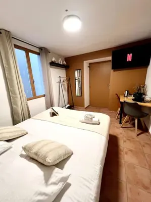 a hotel room with two beds and a desk and a computer at Les chambres de la bastide - 202 in Carcassonne