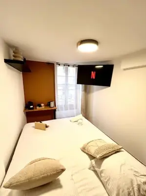 a bedroom with a large bed with a m sign on the wall at Les chambres de la bastide - 204 in Carcassonne