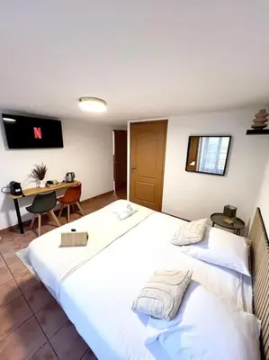 a hotel room with two beds and a desk at Les chambres de la bastide - 205 in Carcassonne