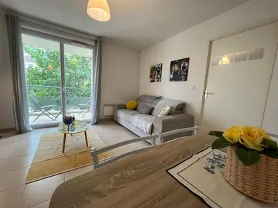 a living room with a couch and a table at T2 Calme et Paisible Parking Piscine in Carcassonne