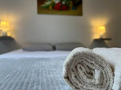 a white bed with a rolled up towel on it at T2 Calme et Paisible Parking Piscine in Carcassonne