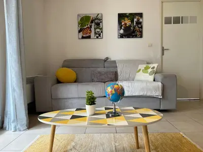 a living room with a couch and a table at T2 Calme et Paisible Parking Piscine in Carcassonne