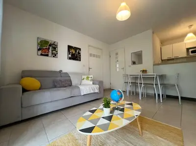 a living room with a couch and a table at T2 Calme et Paisible Parking Piscine in Carcassonne