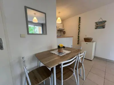 a kitchen with a table and chairs in a room at T2 Calme et Paisible Parking Piscine in Carcassonne